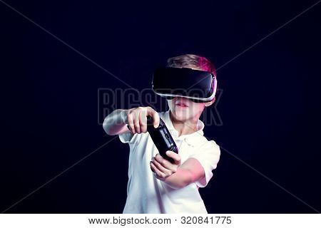 Excited Kid In White T-shirt And Virtual Reality Headset Standing Bending Forward Playing With Joyst