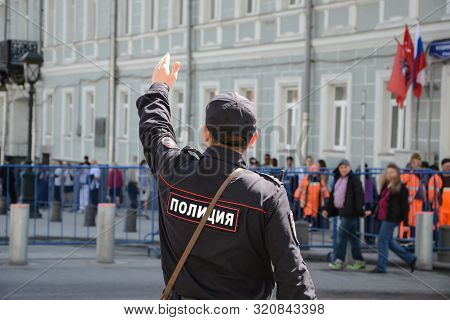 Russian Policeman Officer Standing Back To Camera With Inscription Police On The Uniform Jacket