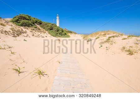 Wooden Planks Footpath Covered On Sand To The Trafalgar Lighthouse