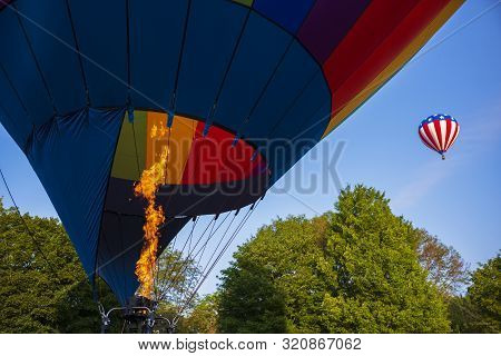Festival Goers Watch Hot Air Balloons Take To Flight Early Saturday Morning On A Cloudless Sky At Th