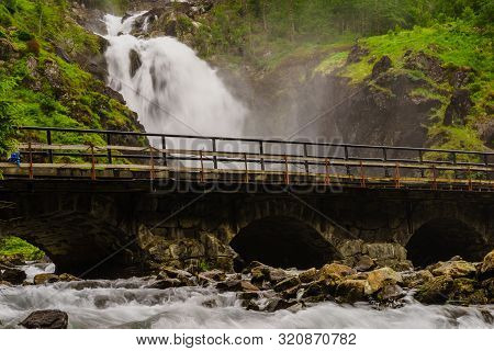 Norwegian Landscape. Waterfall Latefoss Latefossen With Stone Arched Bridge Road, Odda Hordaland Nor
