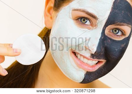 Woman With Clay Carbo Black Mask On One Half Face And White Mud On Second Half. Girl Removing Cosmet