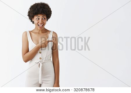 Joyful Attractive Dark-skinned Girl With Curly Hairstyle In Stylish Formal Overalls Being At Festiva
