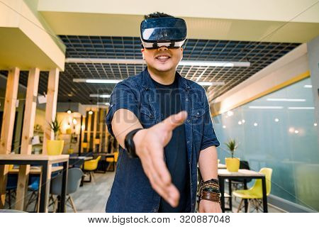 Young Chinese Businessman Working In Office With Virtual Reality Glasses On Head. Man Using Vr Heads