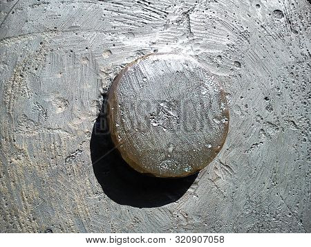 Metal Convex Element With Shadow On A Metal Uneven Background. Roughly Machined Metal Surface With C