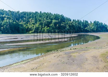 The Nisqually River Flows Past Mud Flats In The Nisqually Wetlands Near Olympia, Washington.