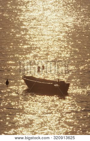 Swimmers And Motor Boat In Backlight. Sunrise In Mediterranean Sea, Solta, Croatia. Summer Vacation.