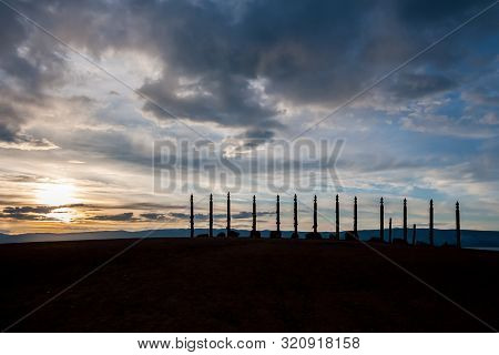 A Sacred Place Of Power With Pillars And Ribbons At Cape Burhan Of Olkhon Island At Sunset. Traditio