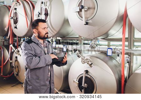 Portrait Of Brewer Who Is Making Beer On His Workplace In The Brew-house..
