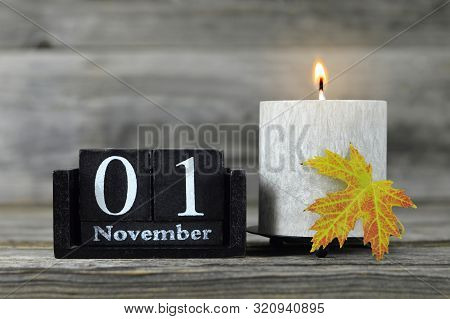 All Saints Day. Burning Candle, Wooden Calendar And Yellow Autumn Leaf