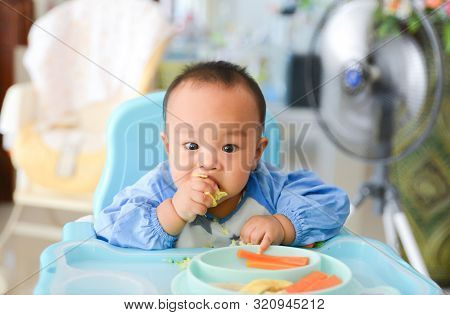 Asian Baby Boy 6 Months Old Eating With Baby Led Weaning (blw) Method, Self-feeding
