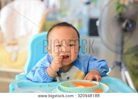 Asian Baby Boy 6 Months Old Eating With Baby Led Weaning (blw) Method, Self-feeding