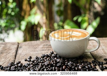 Latte Art Coffee In White Cup With Roast Bean