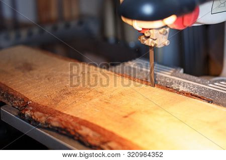 A Craftsman Cutting A Plank Of Wood With Bandsaw. Processing Wood In The Home Workshop. Board Making
