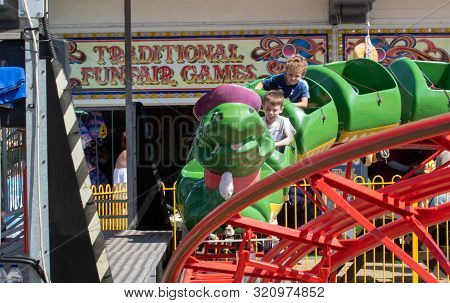 Clacton   United Kingdom 23 August  2019  -:  Young  Boys Enjoying Green Caterpillar Fairground Ride