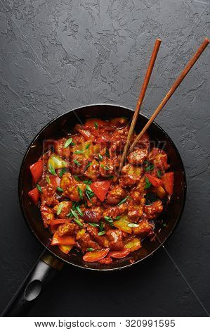 Chicken Manchurian In Pan At Black Concrete Background. Chicken Manchurian Is Indian Chinese Cuisine