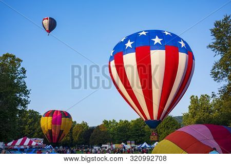 Festival Goers Watch Hot Air Balloons Take To Flight Early Saturday Morning, August 3, 2019 At The S