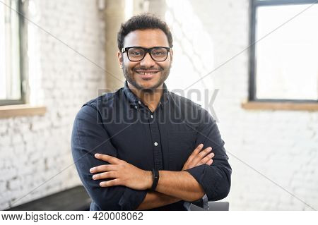 Headshot Of Skilled Hindu Male Employee Standing With Arms Crossed In Modern Office, Successful Conf