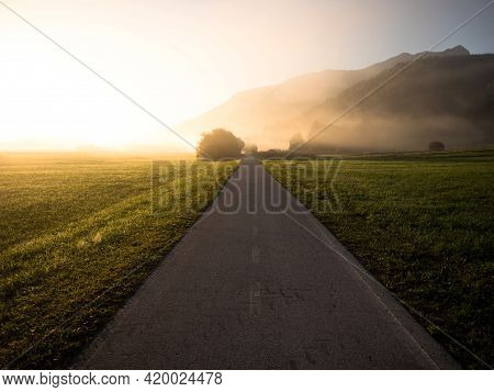Early Morning Sunrise Panorama Of Asphalt Concrete Biking Path Road In Green Nature Landscape Near I