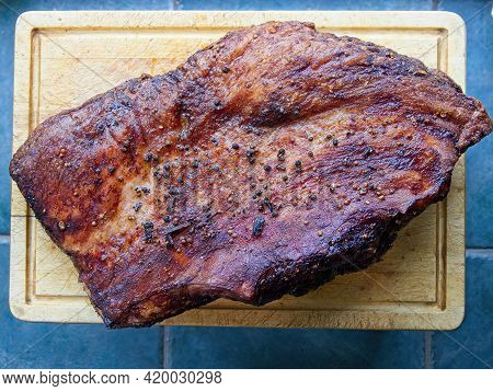 Whole Roasted Beef Brisket Covered With Spices With Darkened Bark On A Wooden Cutting Board