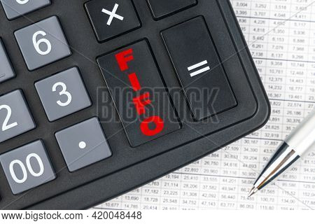 Business And Finance. On The Table Is A Report, A Pen And A Calculator, On The Big Key Of Which Is W