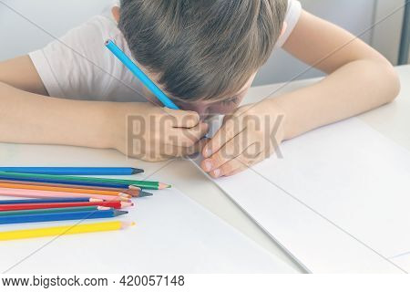 Focused Preschooler Little Boy 5-6 Years Painstakingly Draws Drawing By Pencil. Doing Homework, Draw