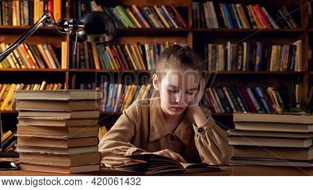 Young Lady In Brown Jacket Reads Training Materials In Textbook Preparing For Lessons Sitting Agains