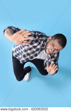 Man Evading Something On Light Blue Background, Above View