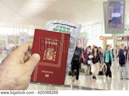 Hand Holding A Spain Passport With A Wrinkled Paper Coronavirus Covid 19 Immunity Certificate Blurre