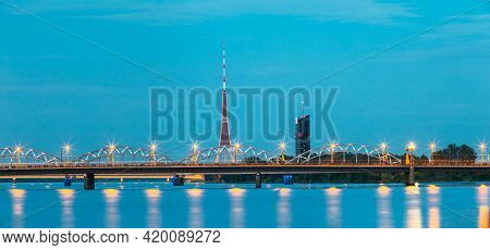 Riga, Latvia. Two Bridges Over Daugava Together: Stone Akmens And Railway Bridge In Evening Illumina