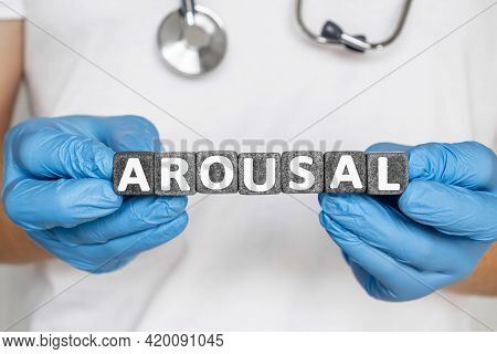 Arousal - Word From Stone Blocks With Letters Holding By A Doctor's Hands In Medical Protective Glov
