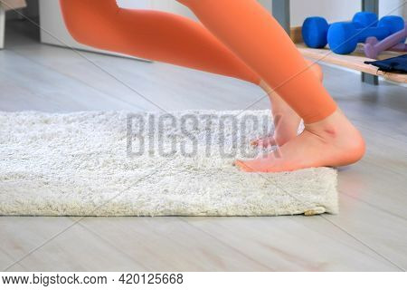 Woman In Sportswear Is Warming Her Feet Practicing Youga Doing Exercises At Home, Closeup Legs. Spor
