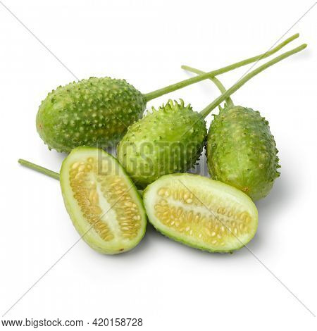 Group of fresh raw whole and halved wild cucumbers close up isolated on white background