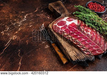 Sliced Cured Coppa Ham On Wooden Board With Thyme. Dark Background. Top View. Copy Space