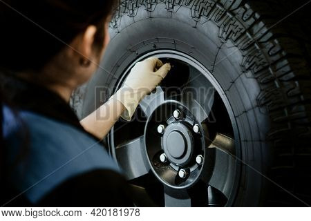 Mechanic opening valve stem on a tire