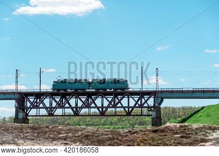 Train Passes Over The Railway Bridge Against The Backdrop Of Green Naturesummer Landscape