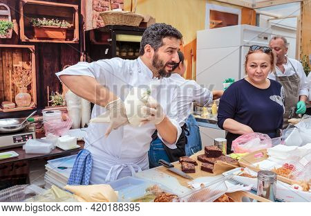 Moscow, Russia, July 13, 2019: An Italian Chef In Uniform Fills A Cream Cone With Cannoli Siciliani 
