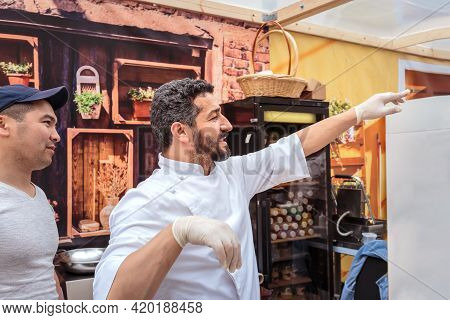 Moscow, Russia, July 13, 2019: An Italian Chef In Uniform Fills A Cream Cone With Cannoli Siciliani 