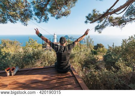 The Tourist Raised His Hands Up, Reaching The Path To The Lighthouse. View Of The Lighthouse Helidon