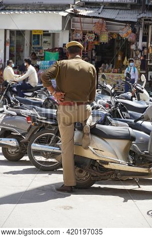 Back View Of A Police (crpf) Personnel Keeping An Eye On A Busy Market In Day Time As Preventive Mea