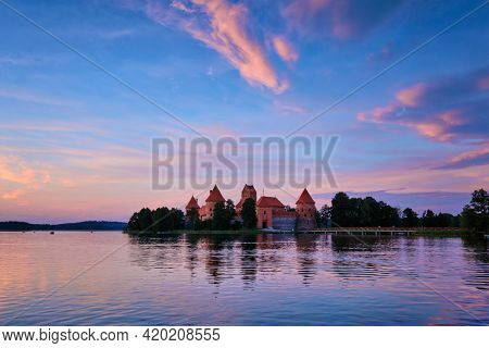 Trakai Island Castle in lake Galve, Lithuania on sunset with dramatic sky reflecting in water. Trakai Castle is one of major tourist attractions of Lituania