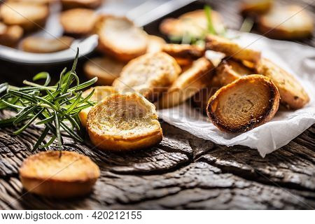 Crunchy And Savory Bake Rolly With Goldish Color Served In The Paper With Fresh Green Rosemary.