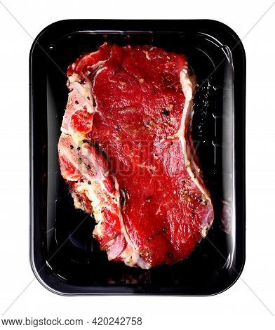 Beaf Steak With Bone Sprinkled With Pepper, On A Food Package Tray, Isolated On A White Background. 