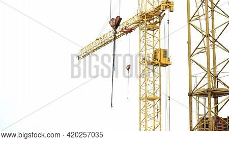 Yellow Crane With Hook And Driver's Cab Against The Sky Close Up