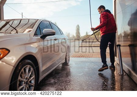 A Man Washes A Car With A Pistol At A Self-service Car Wash
