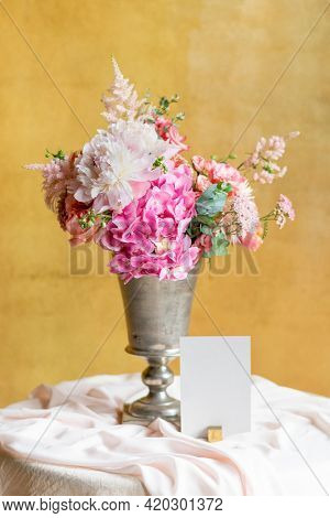 Flower vase by a card on a table