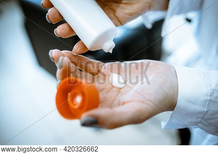 Girl Squeezes Cream Out Of Bottle In Her Hands