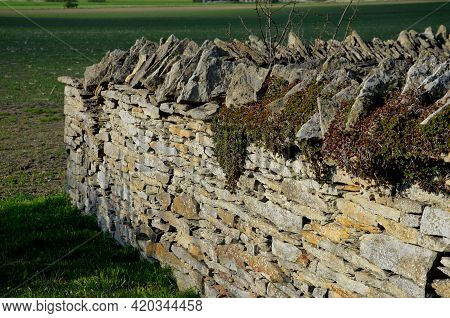 Stone Wall Laid Dry Without The Use Of Cement. The Stones Are Beige-yellow Marl. Stacked On Top Of E