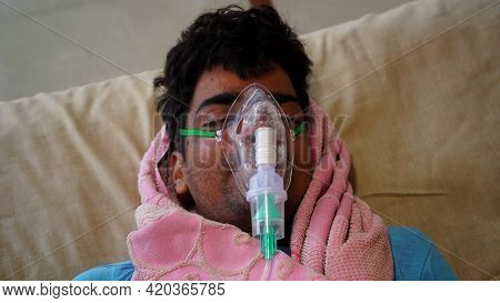 Young Indian Taking Emergency Oxygen With Cannula Outside Of Hospital. Severe Causes Due To Covid In