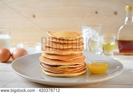 Pancakes With Honey And Ingredients For Cooking On The Table